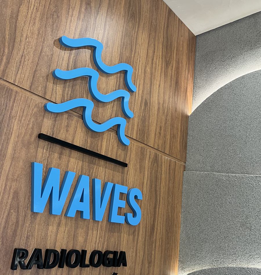 Letreiro da WAVES na parede de madeira da recepção